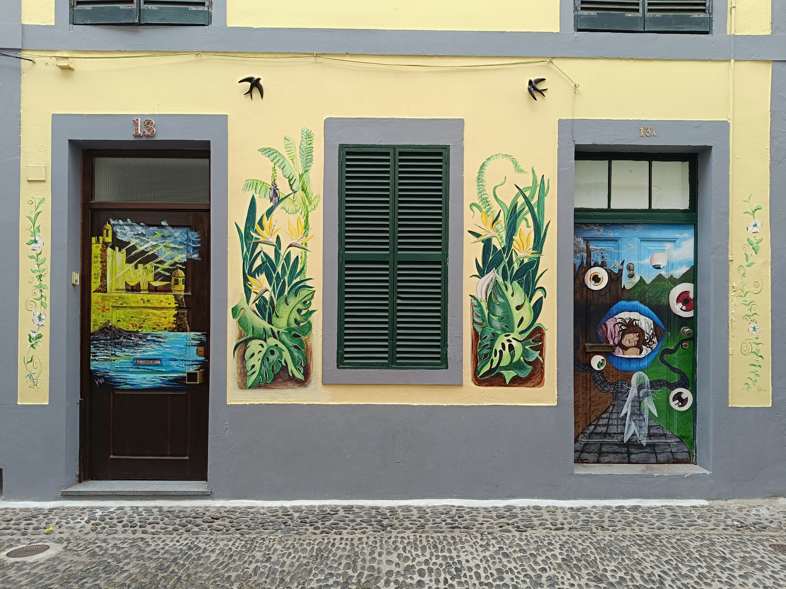 Painted doors and botanical murals on a yellow façade in Funchal’s historic centre